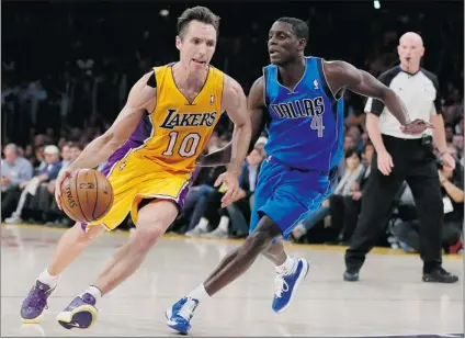  ?? LUCY NICHOLSON/ REUTERS ?? L. A. Lakers point guard Steve Nash takes on Dallas Mavericks point guard Darren Collison in first- quarter action during the game in Los Angeles on Tuesday. Nash was held to just seven points and four assists in his team’s 99- 91 loss.