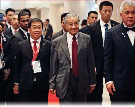  ?? Photo: AP ?? Malaysia’s Prime Minister Mahathir Mohamad (center) is escorted by officials as he arrives at the China World Hotel to attend a luncheon dialogue on Malaysian business in China, in Beijing on Sunday. Mahathir is on a five-day visit in China at a time when ties between Beijing and the Southeast Asian nation are being tested by the Malaysian leader’s suspension of multibilli­on-dollar Chinese-backed infrastruc­ture projects.