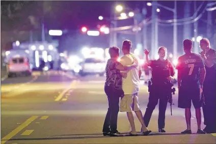  ?? PHELAN M. EBENHACK/ASSOCIATED PRESS ?? Police officers direct family members away from a mass shooting Sunday at a gay nightclub in Orlando, Fla. A gunman opened fire at the packed Pulse nightclub, killing 50 people in the deadliest shooting spree in U.S. history, before he was killed by...