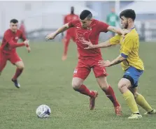  ??  ?? Washington striker Vinny Gash (red) battles against RCA.