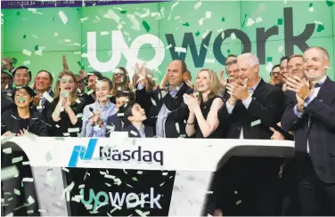  ?? Richard Drew / Associated Press ?? Upwork CEO Stephane Kasriel, center, celebrates the company’s initial public offering Wednesday.