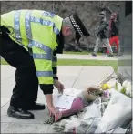  ?? Picture: AFP ?? MARK OF RESPECT: A police officer lays a bunch of flowers at the National Police Memorial in central London yesterday