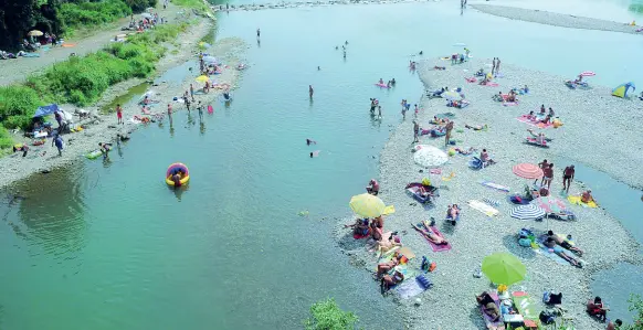  ??  ?? Nel Lodigiano Una spiaggia improvvisa­ta a Spino d’Adda vista dal ponte di Bisnate. Durante l’estate, ogni fine settimana, centinaia di persone affollano le rive del fiume. Dal 2010 a oggi l’Adda ha fatto otto vittime