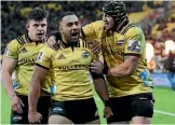  ??  ?? Ngani Laumape, centre, celebrates his try with Hurricanes team-mates Ricky Riccitelli, left, and Jeff Toomaga-Allen.