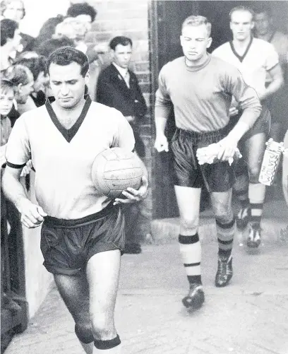  ??  ?? ● Former Wolves footballer Gwyn Jones (right) as the team is led out by Eddie Stewart and Malcolm Finlayson at Molineux. Gwyn, originally from Bangor, pictured below left at Pendine Park’s Bryn Seiont Newydd care home in Caernarfon, has died aged 85