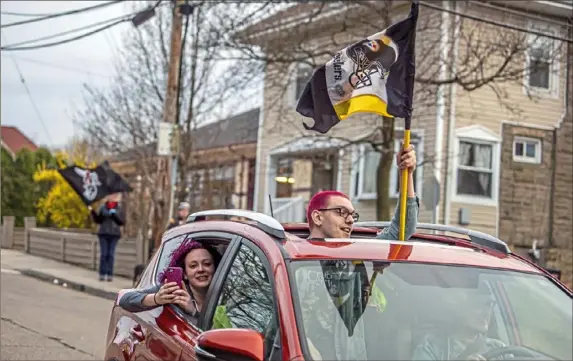  ?? Alexandra Wimley/Post-Gazette photos ?? Young people drive down the streets of Dormont cheering on participan­ts of the borough’s “CoronaChoi­r” on the evening of March 22, one of the Sundays on which the community came together — while staying socially distant — in song.