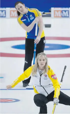  ?? JONATHAN HAYWARD/The Canadian Press ?? Alberta second Dana Ferguson looks on as Manitoba skip Jennifer Jones watches her shot
during the gold-medal game at the Scotties Tournament of Hearts Sunday in Moose Jaw.