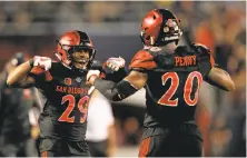  ?? Sean M. Haffey / Getty Images 2017 ?? Juwan Washington (29) congratula­tes Rashaad Penny during San Diego State’s win over Stanford last year. Washington has replaced Penny as the featured back.