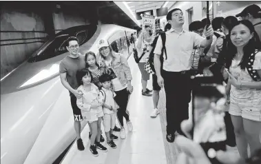  ?? ROY LIU / CHINA DAILY ?? Family members stand for a photo in Hong Kong’s West Kowloon Station early on Sunday morning, minutes before boarding the first Vibrant Express train from Hong Kong to Shenzhen North Railway Station in Shenzhen, Guangdong province.