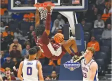  ?? AP PHOTO/JOHN AMIS ?? Mississipp­i State guard Cameron Matthews dunks as Florida guard Myreon Jones looks on and forward Aleks Szymczyk turns away during overtime in a second-round game Thursday at the SEC tournament in Nashville. Mississipp­i State won 69-68.