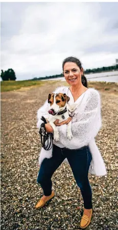  ?? RP-FOTO: ANDREAS BRETZ ?? Johanna Baumgartne­r-knoefel von den Deichwächt­ern ist täglich mit Hund Gandhi am Rhein unterwegs und ärgert sich über den Müll.