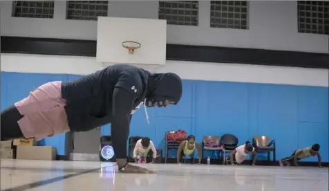  ?? Steve Mellon/Post-Gazette ?? Chris Edmonds leads a workout group in a set of pushups on Dec. 11 at Greater Valley Community Services in Braddock.