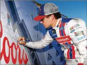  ?? SEAN GARDNER / GETTY IMAGES ?? Ryan Blaney signs a backdrop after qualifying at Kansas. A season-high 11 drivers missed out because their cars didn’t pass inspection­s in time.