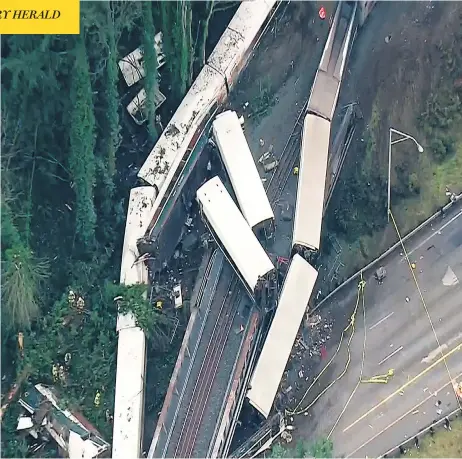  ?? KOMO-TV / VIA THE ASSOCIATED PRESS ?? Cars from a derailed Amtrak train that was travelling from Seattle to Portland, Ore., hang over a highway on Monday. At least three people were killed and 77 others taken to hospital after the train derailed during its inaugural run, spilling passenger...