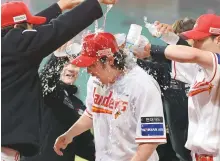  ?? Yonhap ?? SSG Landers’ Choi Jeong, center, is doused with water after tying the Korea Baseball Organizati­on’s career home run record with his 467th home run during a KBO game against the Kia Tigers at Incheon SSG Landers Field in Incheon, Tuesday.