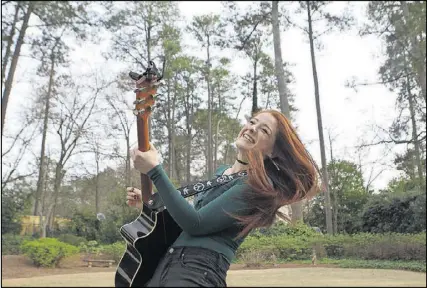  ?? HENRY TAYLOR / HENRY.TAYLOR@AJC.COM ?? Ella Collier, 17, a local musician who experience­d cardiac arrest while playing basketball at the age of 14, practices guitar at her home in Atlanta on Feb. 20. Collier turned her experience on the court into a moment of emotional growth and pursued...