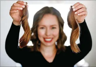  ?? COLUMBUS DISPATCH PHOTOS BY FRED SQUILLANTE / ?? Recently, Ann Mulvany chopped off a 12-inch ponytail to donate to a nonprofit that makes wigs. She packaged up two of her ponytails at her home on April 3 to send to the nonprofit.