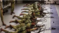  ?? (Amir Cohen/Reuters) ?? SOLDIERS WITH laser rifles are shown in a file photo practicing their reaction to a simulated Palestinia­n attack portrayed on an interactiv­e screen at Camp Tsur, near Yeroham.