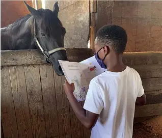  ??  ?? A young reader finds an attentive audience during a July 2020 farm visit.