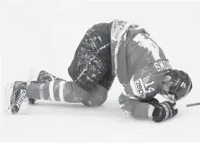  ?? JACQUES BOISSINOT/The Canadian Press ?? Team Canada’s Alex Burrows lies on the ice in pain after he collided with Italy’s Joachim
Ramoser in the first period of Canada’s 6-1 win, Friday.