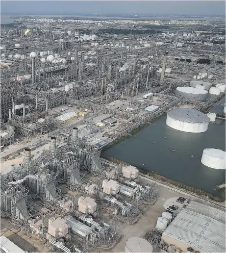  ?? WIN MCNAMEE/GETTY IMAGES ?? An oil refinery is shown near Houston in the aftermath of Tropical Storm Harvey on Tuesday. Mid-continent refining profit margins jumped by about 20 per cent this week, which will boost the bottom lines of Calgary-based Husky and Cenovus, according to...