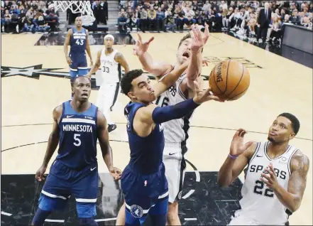  ??  ?? Minnesota Timberwolv­es guard Tyus Jones (1) tries to score past San Antonio Spurs center Pau Gasol (16) and forward Rudy Gay (right), during the firsthalf of an NBA basketball game on Oct 17 in San Antonio. (AP)