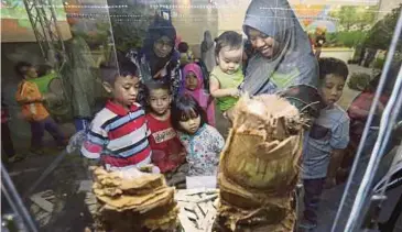  ??  ?? PENGUNJUNG melihat pameran di ruang pameran Upin dan Ipin Kampung Durian Runtuh sempena MAHA 2016 di MAEPS, semalam.