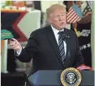  ?? ALEX WONG/GETTY IMAGES ?? President Donald Trump holds up a “Make Our Farmers Great Again” hat Tuesday at the White House.