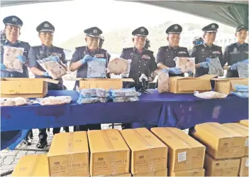  ?? ?? Mohd Nasir (center) and his officers showing the seized frozen chickens.