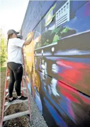  ?? STAFF PHOTO BY MATT HAMILTON ?? On April 12, Chattanoog­a artist Caitlin Maupin paints a mural on the EPB substation fence on 10th Street.