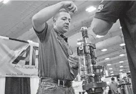  ?? [PHOTOS BY CHRIS LANDSBERGE­R, THE OKLAHOMAN] ?? Jeremy Bird of Anti-Pollution Technology demonstrat­es his company’s leak-detection technology during the Oklahoma Oil & Gas Expo at State Fair Park’s Bennett Center on Thursday.