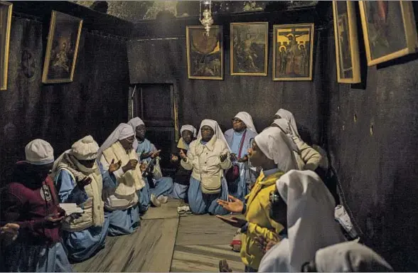  ?? ILIA YEFIMOVICH / GETTY ?? Peregrinas nigerianas rezan en la iglesia de la Natividad de Belén en vísperas de la Nochebuena