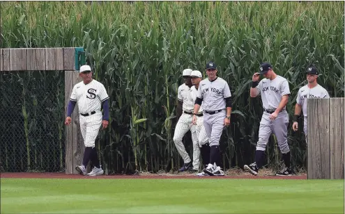  ?? Stacy Revere / Getty Images ?? Members of the Chicago White Sox and the New York Yankees take the field prior to a game at the Field of Dreams on Thursday in Dyersville, Iowa.