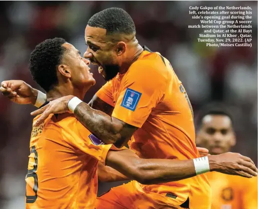  ?? ?? Cody Gakpo of the Netherland­s, left, celebrates after scoring his side's opening goal during the World Cup group A soccer match between the Netherland­s and Qatar, at the Al Bayt Stadium in Al Khor , Qatar, Tuesday, Nov. 29, 2022. (AP Photo/Moises Castillo)