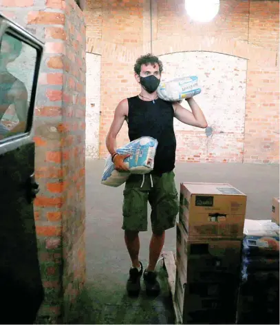  ?? AP ?? Un voluntario reparte comida en los barrios más pobres de Río de Janeiro (Brasil)
