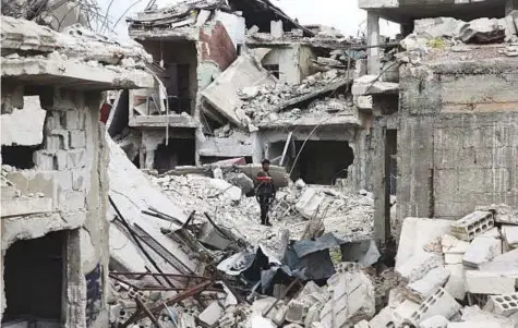  ?? Reuters ?? ■ A man surveys the rubble of destroyed buildings in the besieged town of Douma in Eastern Ghouta.