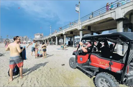  ?? Allen J. Schaben Los Angeles Times ?? IN HUNTINGTON BEACH, officials evacuate the city beach Tuesday during the U.S. Open of Surfing after lightning strikes were reported in the area. The beach later reopened. Flooded roadways were expected until late evening in Lancaster and Palmdale.