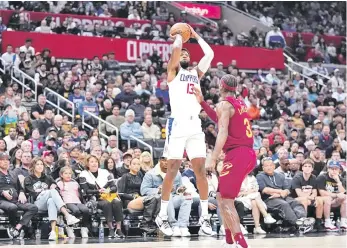  ?? ?? Paul George, de los Clippers, se eleva para encestar un canasto sobre Caris LeVert, de los Cavaliers, en acciónd el partido de ayer en el baloncesto de la NBA.