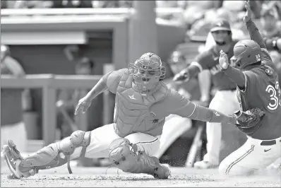  ?? AP Photo/Carlos Osorio ?? Toronto Blue Jays' Ruben Tejada, (33) beats the tag of Philadelph­ia Phillies catcher Deivy Grullon to score during a spring training baseball game Sunday in Dunedin, Fla.