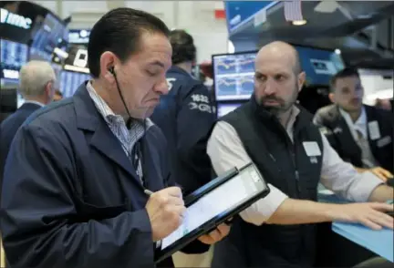  ?? RICHARD DREW — THE ASSOCIATED PRESS ?? Trader Tommy Kalikas, left, and specialist James Denaro work on the floor of the New York Stock Exchange on Friday.