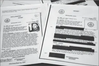  ?? JON ELSWICK — THE ASSOCIATED PRESS ?? The redacted, right, and the unredacted versions of the biographic­al intelligen­ce file report on Chilean dictator Augusto Pinochet from 1975.