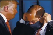  ?? PATRICK SEMANSKY — THE ASSOCIATED PRESS ?? President Donald Trump departs behind Health and Human Services Secretary Alex Azar as Azar puts on a face mask after a roundtable discussion on the coronaviru­s outbreak and storm preparedne­ss at Pelican Golf Club in Belleair, Fla., on July 31.