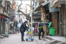  ?? Chinatopix via AP ?? Virus: Government workers spray disinfecta­nt on a garbage can in Wuhan in central China's Hubei Province Tuesday. Hong Kong's leader announced Tuesday that all rail links to mainland China will be cut starting Friday as fears grow about the spread of a new virus.