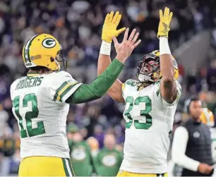  ?? GETTY IMAGES ?? Packers quarterbac­k Aaron Rodgers and running back Aaron Jones celebrate after Jones' touchdown catch against the Ravens last December.