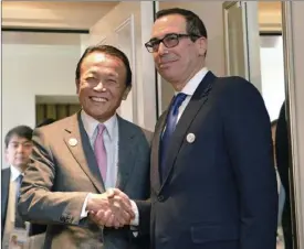  ??  ?? Japanese Finance Minister Taro Aso (left) and U.S. Treasury Secretary Steven Mnuchin meet for talks ahead of the G-20 Finance Ministers meeting Friday in Baden-Baden, southern Germany. AP PHOTO