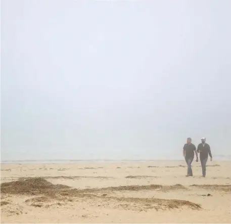  ?? GETTY IMAGES FILE ?? THOUGHT-PROVOKING: Two people take a walk through the fog on Lighthouse Beach in Chatham last summer.