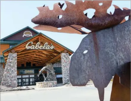  ?? THE ASSOCIATED PRESS ?? Statues of wildlife adorn the entrance to a Cabela’s store in LaVista, Neb. Outdoor gear giants Bass Pro and Cabela’s will combine in a $4.5 billion deal announced Monday.