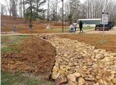  ?? (Photo by Neil Abeles) ?? ABOVE: In Linden’s City Park, white stones are being placed for the new storm drainage control project that has included an earthen dam and retention pond. The creation of the rock channels are called "bioswales," which are drainage ditches that help filter the water in a more natural way through the use of river rock and native plants. Three bioswales are in the park, two feeding the retention pond on the south side and a third along the north end of the park below the amphitheat­er, according to city official Allie Anderson.