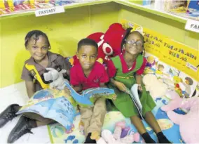  ?? ?? Pell River students (from left) Kacia Earle, Liam Owens and Kylie Jones sit down for a quiet and cozy reading session in their newly renovated library.