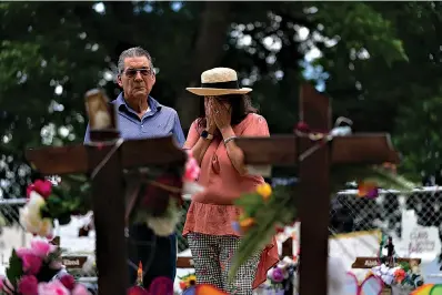  ?? AP Photo/Jae C. Hong ?? ■ Helen Torres, who said she just became a grandmothe­r, weeps as she visits a memorial with her husband, Ruben, on Thursday in Uvalde, Texas. Nineteen students and two teachers were killed in last week’s shooting at Robb Elementary School.